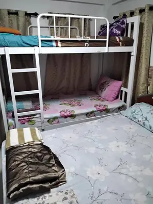 a bedroom with two bunk beds with a ladder at Danee Hostel in Bangkok