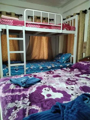 a bedroom with two bunk beds and a purple bed at Danee Hostel in Bangkok