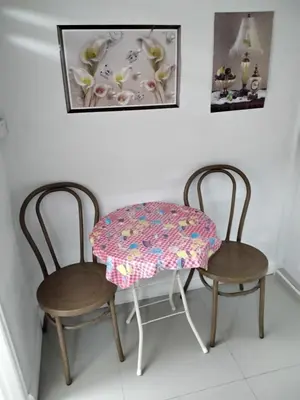 two chairs and a table with a table cloth on it at Danee Hostel in Bangkok