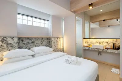 a bedroom with a white bed with white pillows at Metz Pratunam in Bangkok