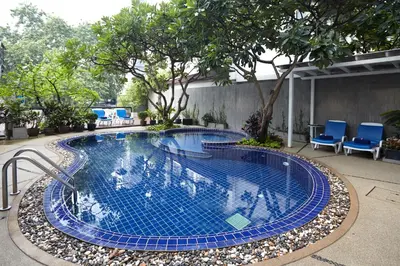 a swimming pool in a yard with blue chairs at Anya Nana at Sukhumvit Bangkok in Bangkok