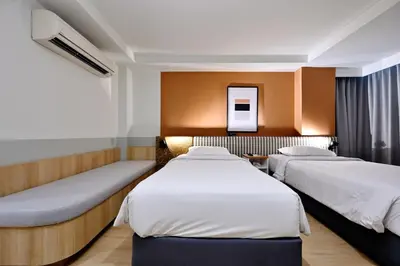 a hotel room with two beds and a mirror at Anya Nana at Sukhumvit Bangkok in Bangkok