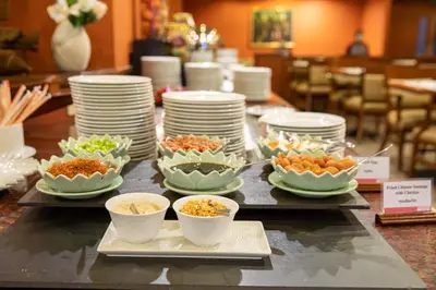 a buffet with plates and bowls of food on a table at Ramada by Wyndham D MA Bangkok in Bangkok