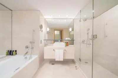 a bathroom with a tub and a sink and a shower at Holiday Inn Bangkok Silom by IHG in Bangkok