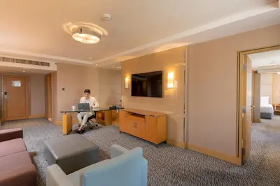 a man sitting at a desk in a hotel room at Holiday Inn Bangkok Silom by IHG in Bangkok