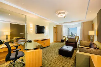 a hotel room with a living area with a television at Holiday Inn Bangkok Silom by IHG in Bangkok