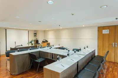 a conference room with a long table and chairs at Seasons Siam Hotel in Bangkok