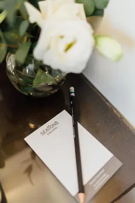 a pen sitting on a table next to a bowl of flowers at Seasons Siam Hotel in Bangkok