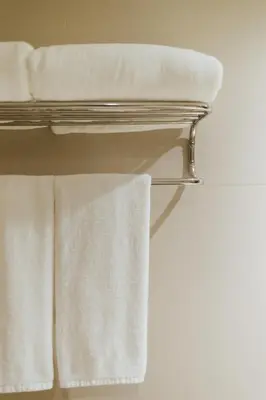a towel rack with white towels on it at Seasons Siam Hotel in Bangkok