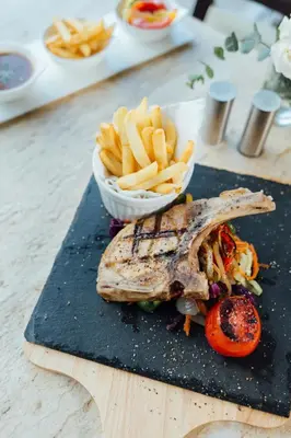 a plate of food and a bowl of french fries at Seasons Siam Hotel in Bangkok