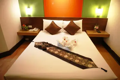 a hotel room with a bed with a bow tie on it at The Seasons Bangkok Huamark in Bangkok