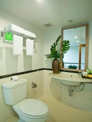 a white bathroom with a toilet and a sink at The Seasons Bangkok Huamark in Bangkok
