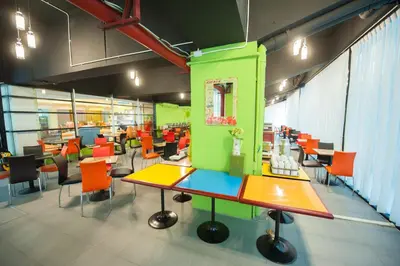 a room with colorful tables and chairs in a building at The Seasons Bangkok Huamark in Bangkok