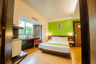 a hotel room with a bed and a desk at The Seasons Bangkok Huamark in Bangkok