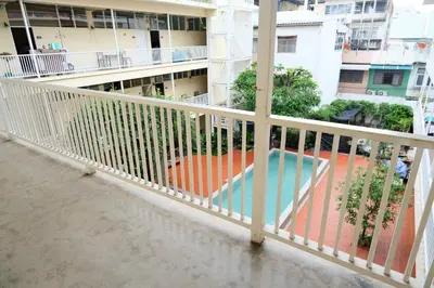 a balcony with a white railing and a swimming pool at Feung Nakorn Balcony Rooms and Cafe in Bangkok