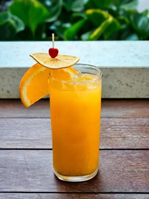 a glass of orange juice with an orange slice at Feung Nakorn Balcony Rooms and Cafe in Bangkok