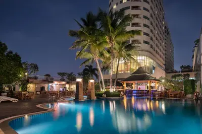 a hotel with a swimming pool in front of a building at Prince Palace Hotel Bangkok in Bangkok