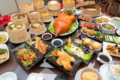 a table with many plates of food on it at Ambassador Hotel Bangkok in Bangkok