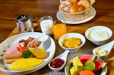 a table topped with plates of food and drinks at Ambassador Hotel Bangkok in Bangkok