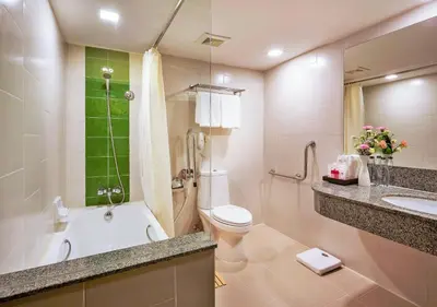 a bathroom with a tub and a toilet and a sink at Ambassador Hotel Bangkok in Bangkok