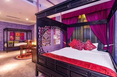 a bedroom with a large bed with red pillows at Shanghai Mansion Bangkok in Bangkok