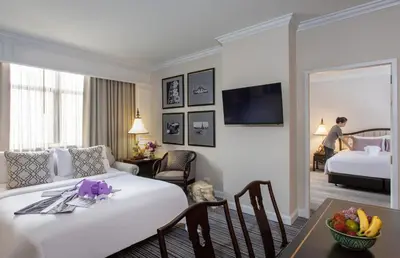 a hotel room with a bed and a table and a room at The Sukosol Hotel in Bangkok
