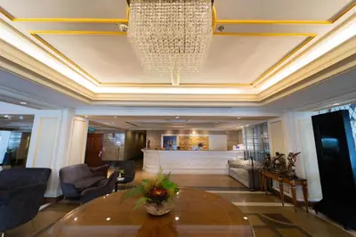 a lobby with a table and a chandelier at Forum Park Hotel in Bangkok