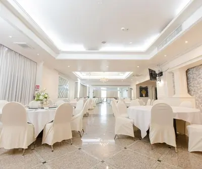 a banquet hall with white tables and white chairs at Forum Park Hotel in Bangkok