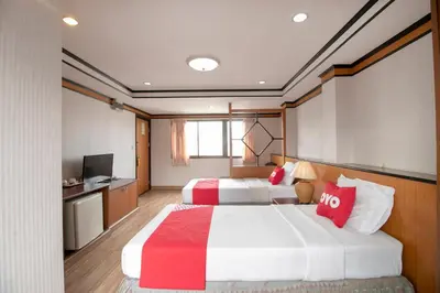 a hotel room with two beds and a television at Hotel Win Long in Bangkok
