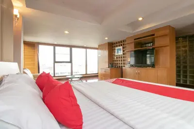 a bedroom with a large bed with red pillows at Hotel Win Long in Bangkok