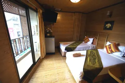a small room with two beds and a window at Thai Cozy House in Bangkok