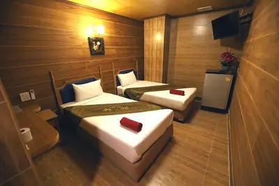 a room with two beds and a tv in it at Thai Cozy House in Bangkok