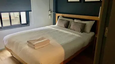 a bedroom with a large bed with towels on it at The Chatbox Silom Hostel in Bangkok