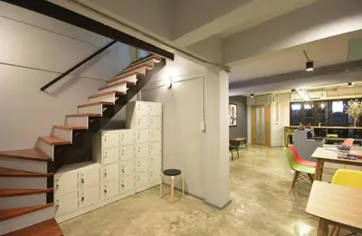 a staircase in a room with a table and chairs at The Chatbox Silom Hostel in Bangkok