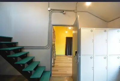 a room with green stairs and a hallway at The Chatbox Silom Hostel in Bangkok