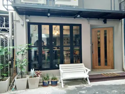 a white bench sitting in front of a building at The Chatbox Silom Hostel in Bangkok