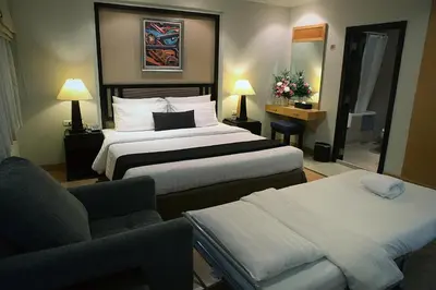a hotel room with two beds and a couch at The Key Bangkok Hotel in Bangkok
