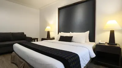 a hotel room with a large bed and a couch at The Key Bangkok Hotel in Bangkok