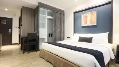 a hotel room with a large bed and a desk at The Key Bangkok Hotel in Bangkok
