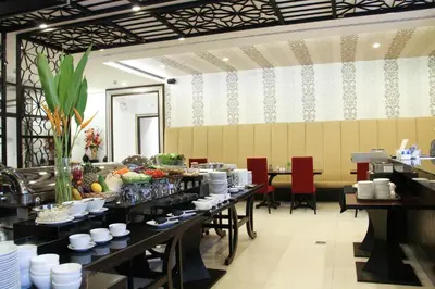 a dining room with tables with plates of food at FuramaXclusive Sukhumvit in Bangkok