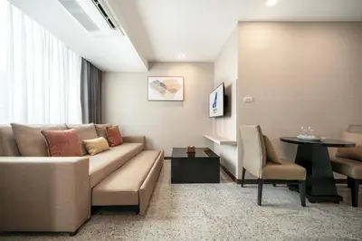 a living room with a couch and a table at Adelphi Suites Bangkok in Bangkok