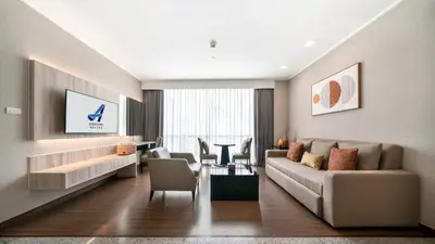 a living room with a couch and a table at Adelphi Suites Bangkok in Bangkok