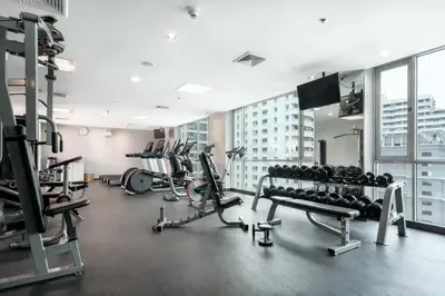 a gym with treadmills and machines in a building at Adelphi Suites Bangkok in Bangkok