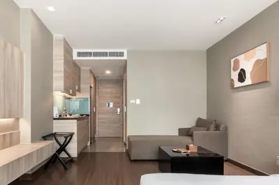 a living room with a couch and a table at Adelphi Suites Bangkok in Bangkok