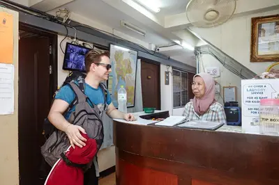 a man and a woman standing at a cash register at Amarin Inn in Bangkok