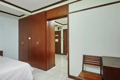 a bedroom with a bed and a desk and a chair at Amarin Inn in Bangkok