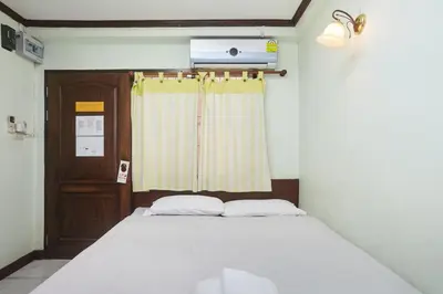a bedroom with a bed and a window at Amarin Inn in Bangkok