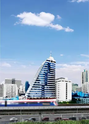 a city skyline with a tall building and a train at NH Bangkok Sukhumvit Boulevard in Bangkok