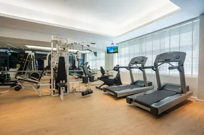 a gym with treadmills and cardio equipment in a room at NH Bangkok Sukhumvit Boulevard in Bangkok