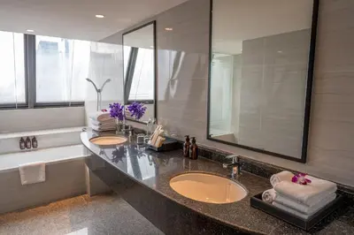 a bathroom with two sinks and a large mirror at NH Bangkok Sukhumvit Boulevard in Bangkok